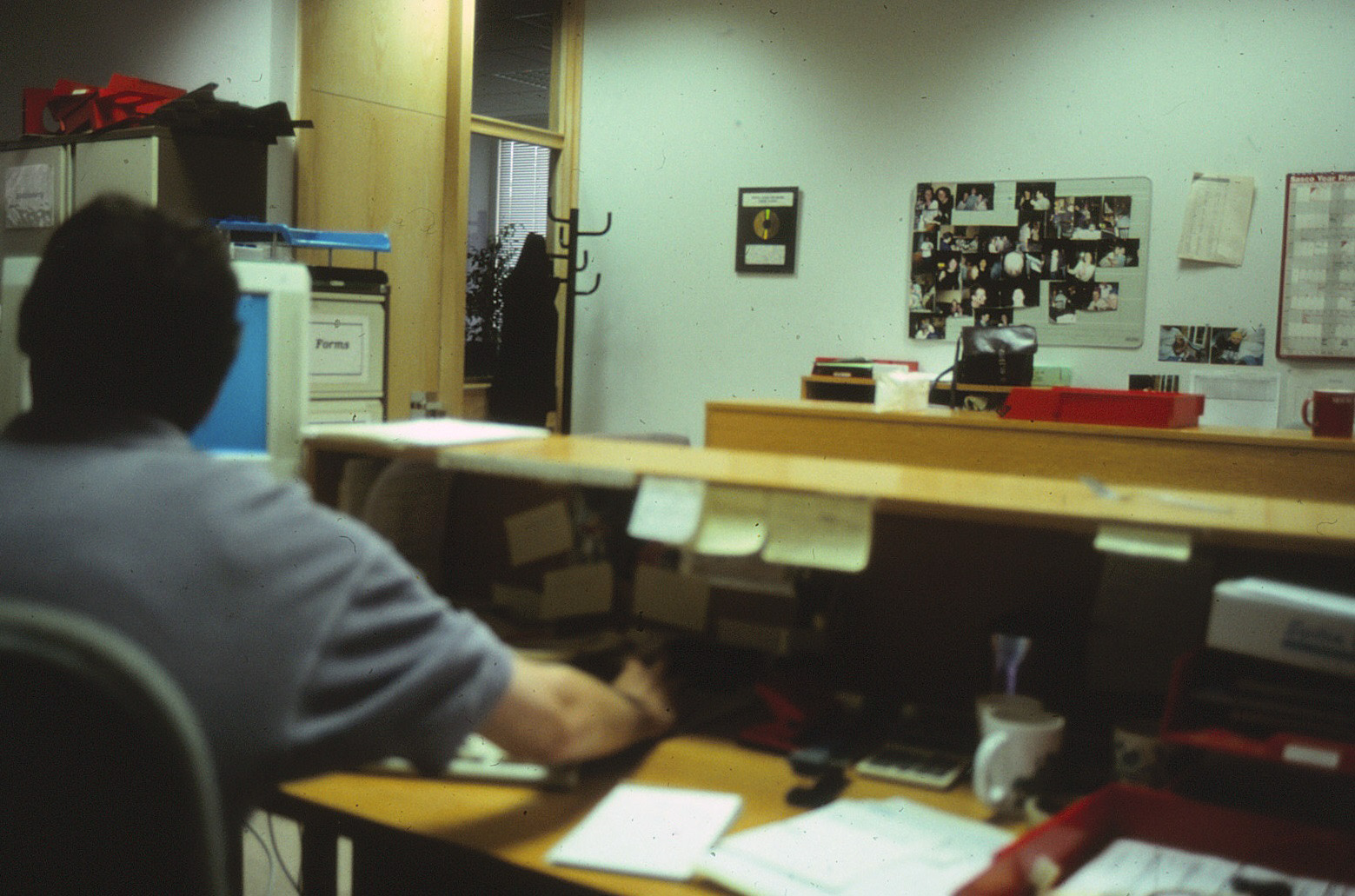 Software engineer working at a CRT computer workstation in an office in July 1997.